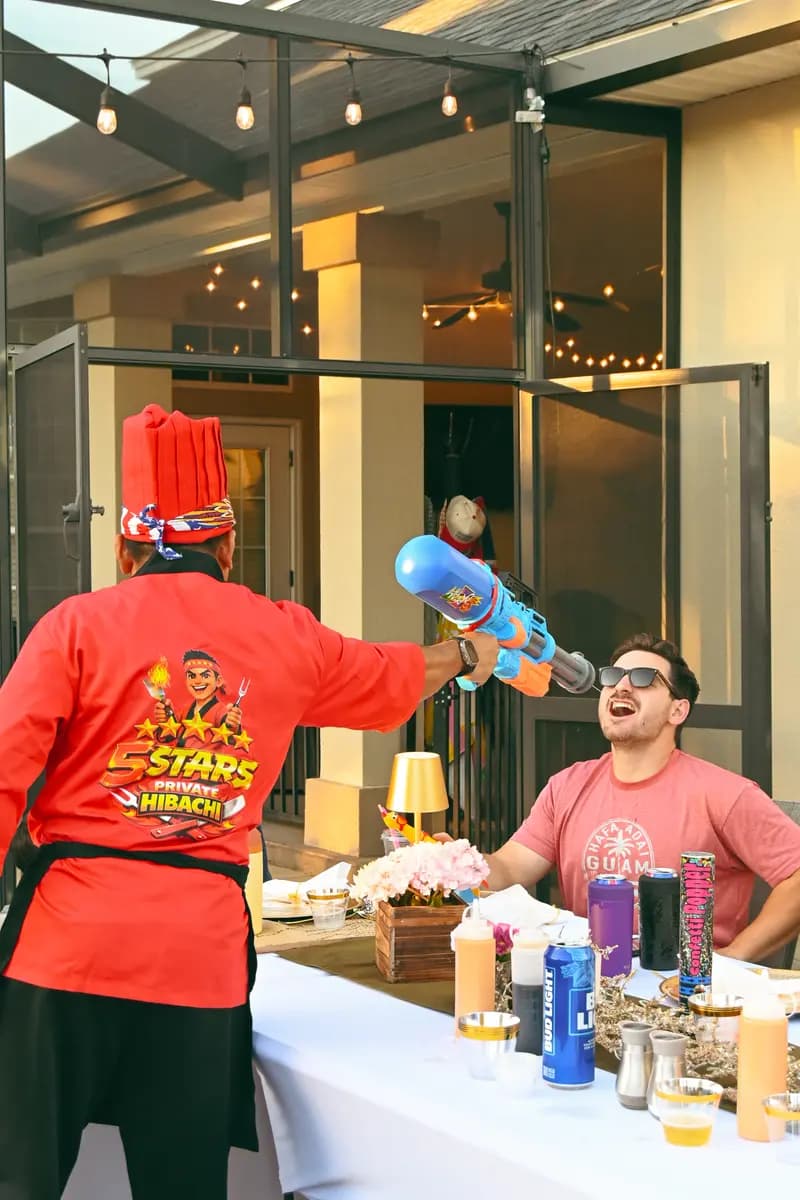 Hibachi chef shooting sake into guests mouth